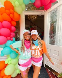 two young women standing in front of a doorway with balloons and streamers behind them