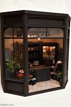 the inside of a building with potted plants and flowers in it's windows