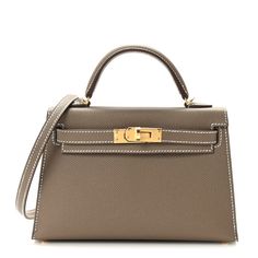 This is an authentic HERMES Epsom Mini Kelly Sellier 20 in Etoupe. This stunning Hermes classic handbag is beautifully crafted in stamped epsom calfskin leather in taupe. A single rolled leather top handle is secured with gold plated hardware and an optional leather shoulder strap is included. The traditional Kelly turn lock secures the small flap. The interior features a matching chevre goatskin leather with a single flat pocket. Hermes Small Bag, Mini Kelly Etoupe, Mini Hermes Bag, Mini Kelly Hermes, Hermes Etoupe, Hermes Collection, Bag Closet, Mini Kelly, Kelly Sellier