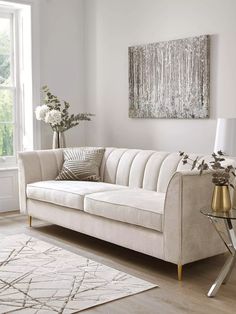 a living room with a couch, rug and table in front of a large window