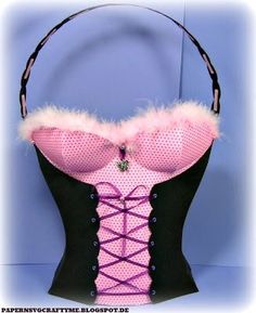 a corset with pink and black trimmings on the front, attached to a headband