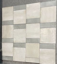 a white and grey tiled wall on the side of a building