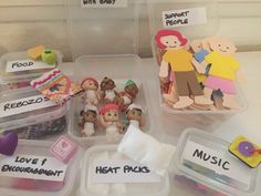 several plastic containers filled with different types of toys and magnets on top of a table