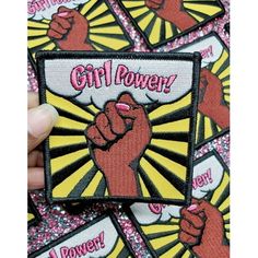 someone holding up a patch with the words girl power on it