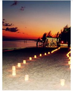 there are many lit candles on the beach