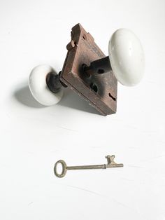 an antique door knob and key on a white surface