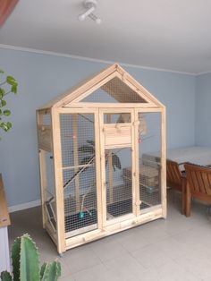 a large wooden bird cage sitting in the corner of a room next to a bed