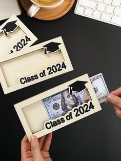 two handmade graduation magnets sitting on top of a desk next to a keyboard