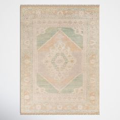 an antique rug with green and beige colors