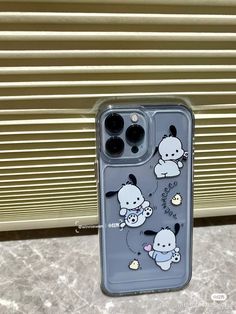 an iphone case with cartoon animals on it sitting next to a window sill and blinds