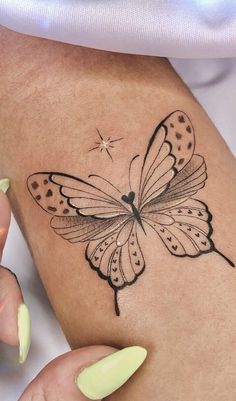 a woman's arm with a butterfly tattoo on it