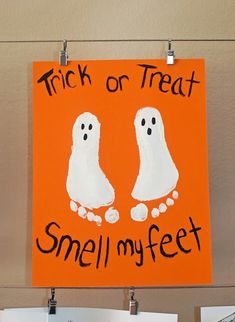 a sign that says trick or treat smell my feet on an orange and white background