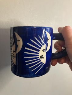 A solar eclipse design mug is handmade using the slab method in pottery. The design was made by paper cut outs with underglaze added over top. It was then peeled away leaving a ghost-like design.   The inside of the mug is glazed with a white and a clear glaze on the outside. The size of mug is 3.5 inch tall by 3 wide in the opening. It holds 12oz of liquid. It is microwavable safe and dishwasher safe.  The slab method is a fun way to make pottery. All mugs are created by hand and have a made by Celestial Illustration, Eclipse Design, Drink Ware, Mug Design, Paper Cutout, Solar Eclipse, Sun And Moon, Mug Coffee, Paper Cut