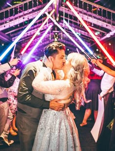 a bride and groom kissing on the dance floor