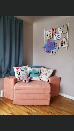 a living room with a pink couch and blue curtains