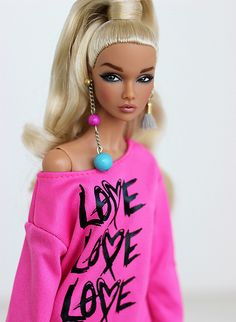 a barbie doll wearing a pink sweater with the words love and love written on it