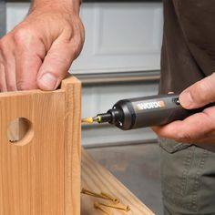 a man using a drill to attach a piece of wood with a screwdriver