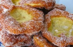 powdered sugar covered donuts stacked on top of each other in a blue and white plate