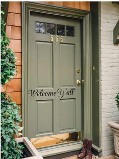 welcome y'all wall decal on the front door of a house with boots and potted plants