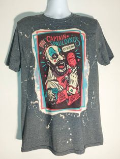 a gray t - shirt with an image of a clown on it