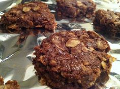 chocolate cookies with nuts on top sitting on aluminum foil