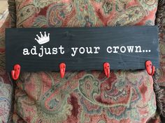 a sign that says, adjust your crown on the back of a chair with red pegs