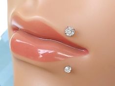 a close up view of a woman's lips with diamond studs