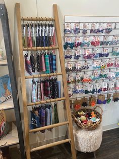 a wooden ladder next to a display rack with ties on it