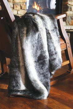 a rocking chair with a blanket on top of it next to a fire place in a fireplace