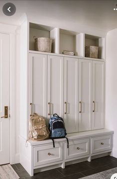 a room with white cabinets and bags on it