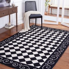 a black and white checkered rug with a chair in the corner next to it