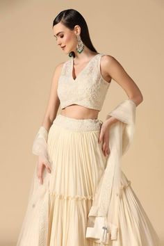 White can can attached lehenga skirt in a pleated tiered base with pearl embroidered waistband. Comes with padded pearl floral embroidered blouse and dupatta.
Components: 3
Pattern: Embroidered
Type Of Work: Pearl
Neckline: V-neck
Sleeve Type: Sleeveless
Fabric: Lehenga: Georgette, Blouse: Net
Color: White
Other Details: 
Closure:
Blouse: Back hook
Lehenga: Side drawstring
Occasion: Sangeet - Aza Fashions Anarkali Choli With Tiered Skirt For Wedding, Wedding Anarkali Choli With Tiered Skirt, Elegant Tiered Sharara For Wedding, Elegant Tiered Skirt Sharara For Wedding, Elegant Wedding Choli With Tiered Skirt, Elegant Sleeveless Choli With Pearl Embroidery, Sleeveless Lehenga With Pearl Embroidery, Elegant Sleeveless Lehenga With Sheer Dupatta, Elegant Tiered Lehenga