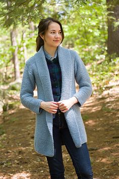 a woman standing in the woods with her hands on her hips