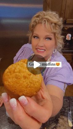 a woman holding up a muffin in her hand with the caption gf mfins