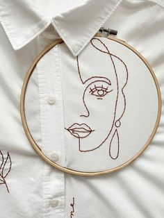 a woman's face is embroidered on a white shirt