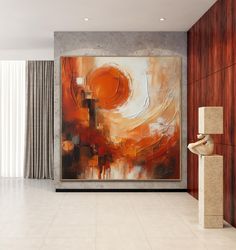 an abstract painting hangs on the wall next to a large window in a modern living room