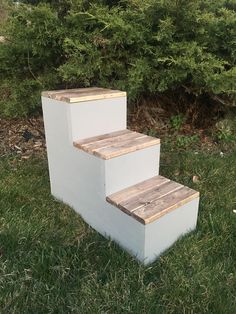 three wooden steps sitting in the grass