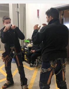 two men in protective gear standing next to each other and one man wearing a face mask