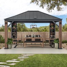 a gazebo sitting on top of a lush green field next to a wooden fence