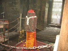 a shrine with chains around it and an orange bag on the ground next to it