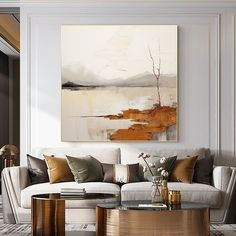 a living room filled with furniture and a large painting on the wall above it's coffee table