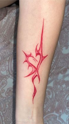 a woman's arm with a red tattoo design on the left side of her leg