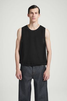 The COS menswear team have been creating elevated wardrobe essentials since the beginning. This upgraded sweater tank is testament to that ethos – designed for a relaxed fit, it's been knitted using a racking stitch that gives the organic cotton fabric a beautifully intricate texture. Wear it with a simple chain hanging over the crew neckline. Round neckSleeveless, tubular trimsOrganic cotton is grown from non-genetically modified seeds without chemical fertilizers or pesticides Shell: 100% Orga Black Knit Streetwear Tops, Relaxed Fit Cotton Crew Neck Sweater Vest, Casual Crew Neck Sweater Vest Relaxed Fit, Cotton Knit Tops For Streetwear, Relaxed Fit Cotton Sweater Vest For Layering, Sleeveless Knit Tops With Relaxed Fit, Cos Menswear, Simple Chain, Cotton Vest