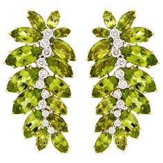 A delicate silhouette of a leaf is illustrated by lustrous peridots and brilliant cut diamonds for these drop earrings. The earrings feature various marquise cut peridots in verdant hues fanned outward. To emulate the pattern on the leaf, graduated diamonds trace down the center. The brilliant cut diamonds are DEF color and VS1 clarity emitting a bright fire. The total weight of the gems is 1.63 carats of diamonds and 32.4 carats of peridots. Clip-backs secure the earrings, which measure 23.62 m Peridot Jewelry, Peridot Earrings, Gold Leaf Earrings, Yellow Gold Earrings, Leaf Motif, Harry Winston, White Gold Earrings, Vintage Clip, Fabulous Jewelry