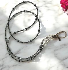 Elevate your professional look with this simple Beaded Lanyard in Black and Gray, ideal for holding your ID badge securely. This interchangeable seed bead ID card chain is a perfect gift idea for doctors, nurses, or anyone needing a stylish and practical accessory. Included in your purchase are a pair of eyeglass chain ends and a lanyard clasp. To switch, simply use the small clasps at each end of the beaded chain.  This black and gray lanyard is 30 inches long. To see more of my new projects fo Or Nurse, Beaded Lanyard, Simple Gift, Beaded Lanyards, Doctor Gifts, Eyeglass Chain, Glasses Chain, Id Badge Holders, Simple Gifts