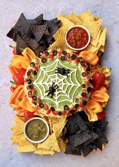 a platter with chips, salsa and guacamole on it next to tortilla chips