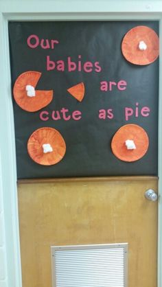 a door decorated with oranges and white paper on it's side that says our babies are cute as pie