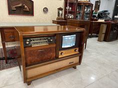 an old fashioned radio sitting on top of a wooden table in a room filled with furniture