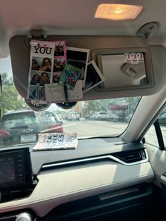 the inside of a car with pictures on the dash board and magazines hanging from the dashboard