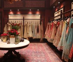 a room filled with lots of dresses and vases on top of a white table